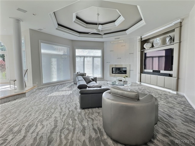 carpeted living room with a wealth of natural light, a tray ceiling, and ceiling fan