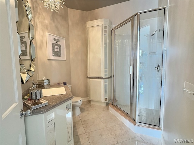 bathroom with vanity, a notable chandelier, toilet, and an enclosed shower