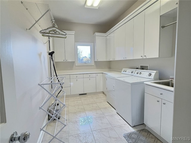 washroom featuring cabinets and separate washer and dryer