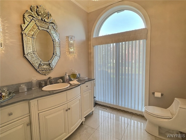 bathroom with toilet, ornamental molding, vanity, and tile patterned flooring