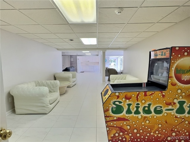 rec room with a paneled ceiling and tile patterned flooring