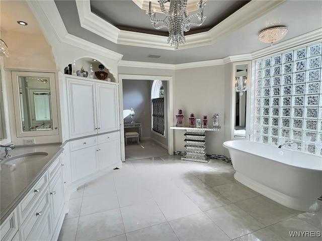 bathroom featuring a bathing tub, tile patterned flooring, crown molding, a raised ceiling, and vanity