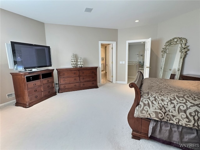 bedroom featuring a closet, light colored carpet, connected bathroom, and a walk in closet