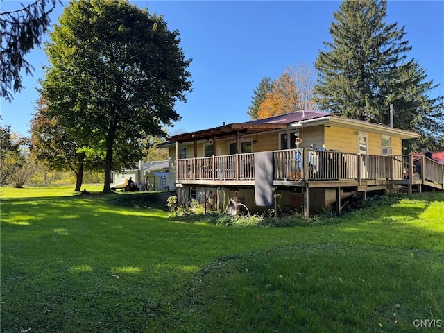 back of property with a wooden deck and a yard