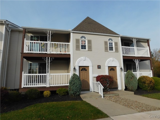 view of property featuring a balcony and a porch