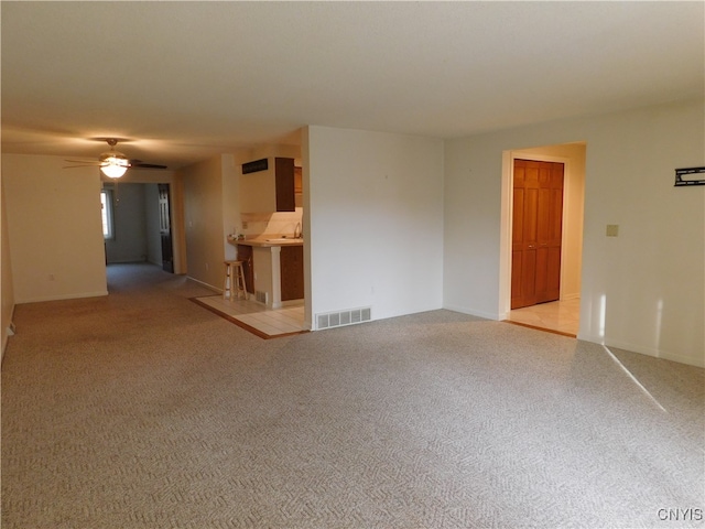 empty room featuring light colored carpet, sink, and ceiling fan