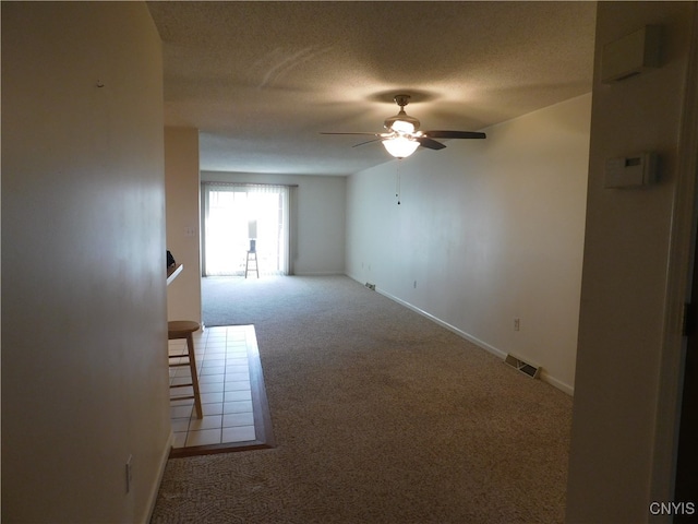 spare room featuring ceiling fan, carpet flooring, and a textured ceiling