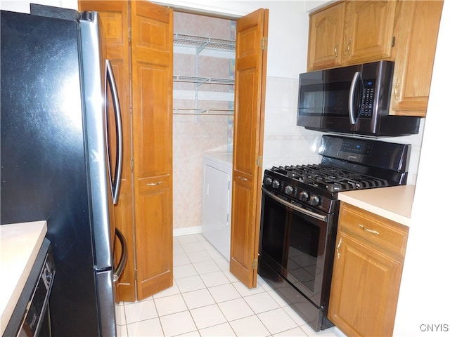 kitchen with backsplash, stainless steel appliances, washer / clothes dryer, and light tile patterned flooring