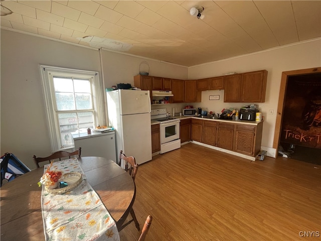 kitchen featuring white appliances, crown molding, and hardwood / wood-style floors