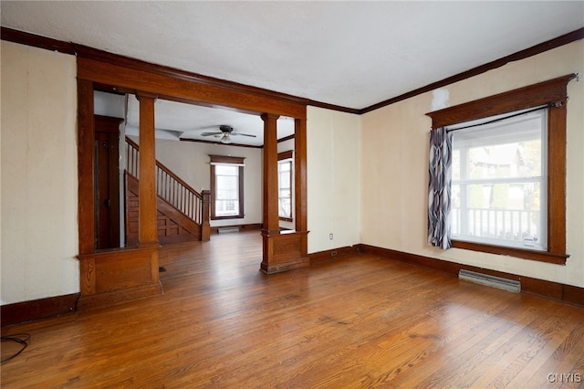 unfurnished living room featuring ornamental molding, decorative columns, hardwood / wood-style floors, and ceiling fan