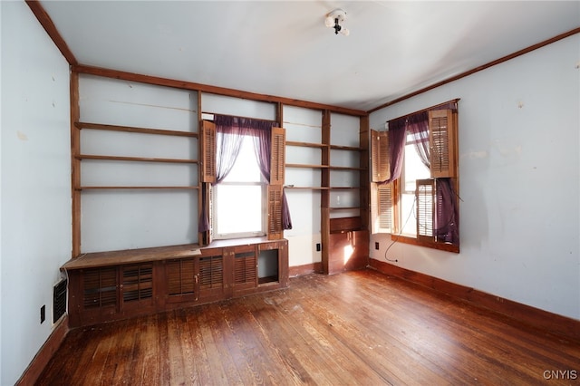 unfurnished living room featuring a wealth of natural light and hardwood / wood-style floors