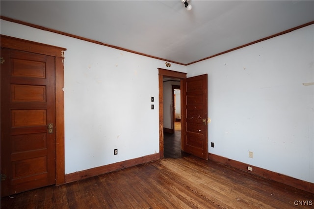 empty room featuring ornamental molding and dark hardwood / wood-style floors