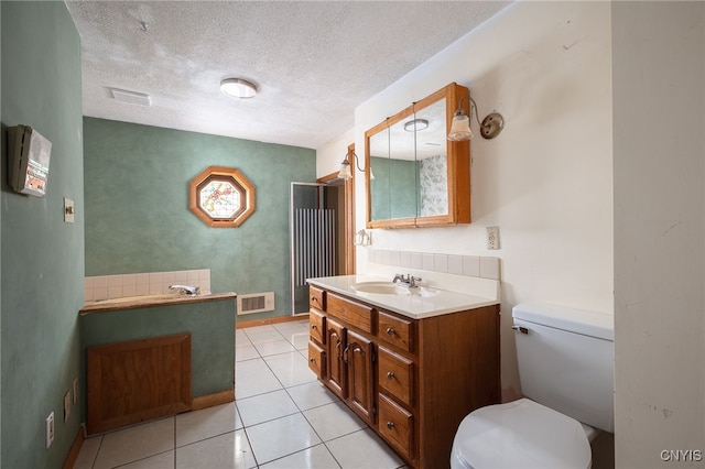 bathroom with vanity, a textured ceiling, toilet, and tile patterned floors