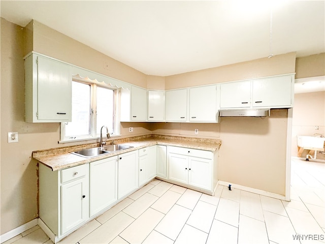 kitchen with white cabinets, sink, and light tile patterned floors