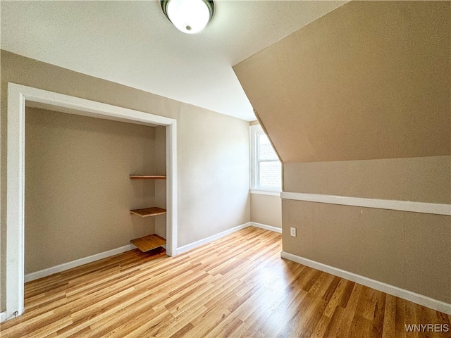 bonus room featuring lofted ceiling and light hardwood / wood-style flooring