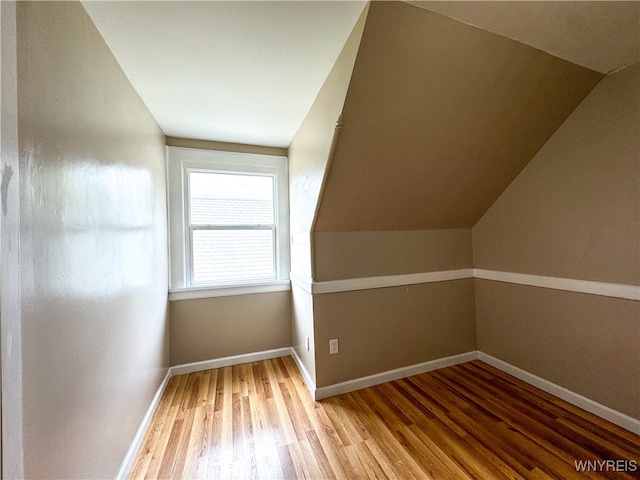 bonus room with lofted ceiling and hardwood / wood-style floors