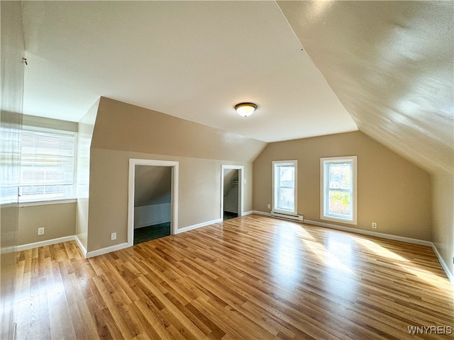 bonus room with vaulted ceiling and light hardwood / wood-style flooring