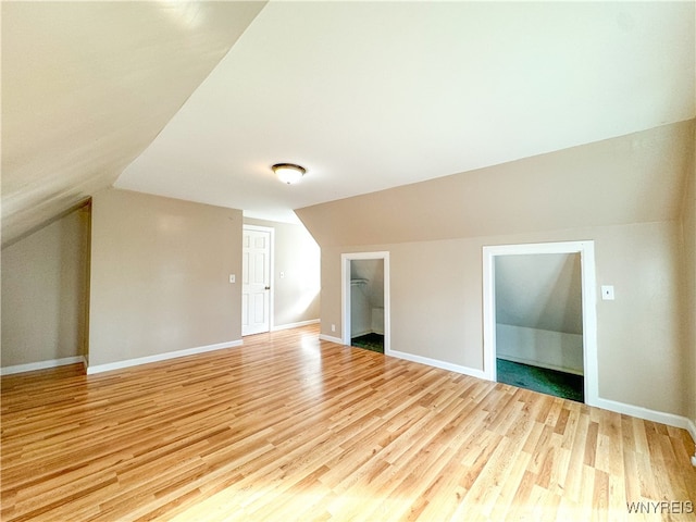 bonus room with lofted ceiling and light wood-type flooring