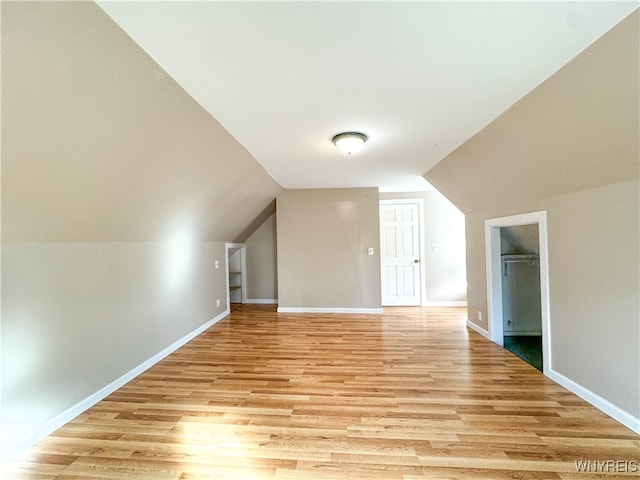 additional living space featuring light hardwood / wood-style floors and vaulted ceiling