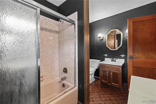 full bathroom with vanity, bath / shower combo with glass door, toilet, and tile patterned floors