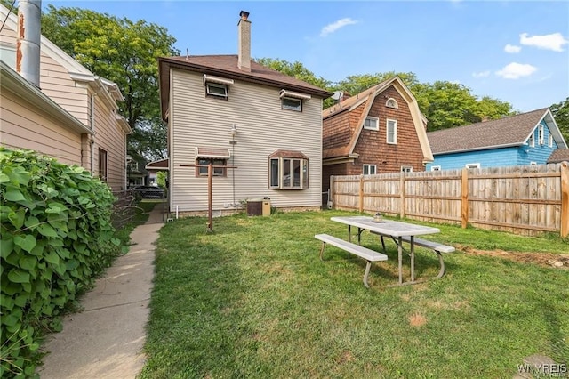 rear view of property featuring cooling unit and a yard