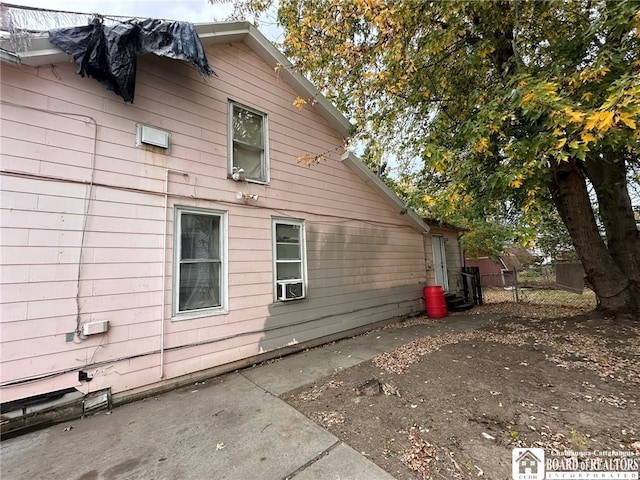 view of side of home featuring cooling unit and a patio