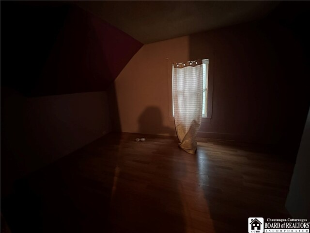 bonus room with dark wood-type flooring and lofted ceiling