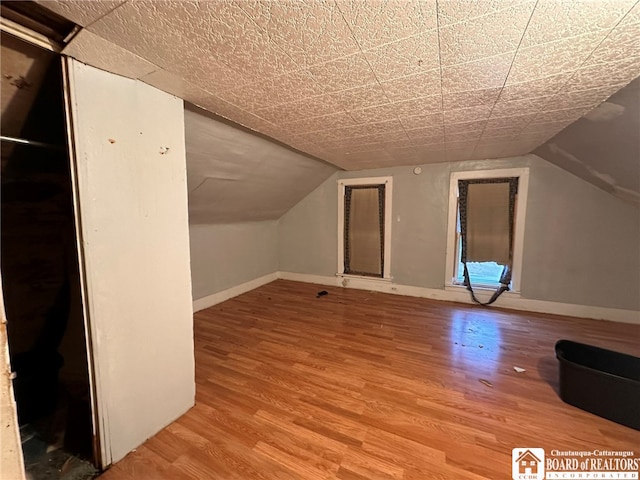 bonus room featuring lofted ceiling and hardwood / wood-style flooring