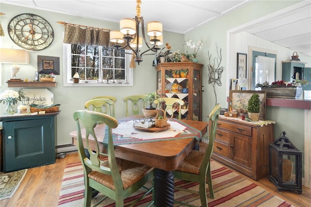 399 Fire Lane 34, Moravia, NY 13118 - dining space with a healthy amount of sunlight, light wood finished floors, a chandelier, and crown molding