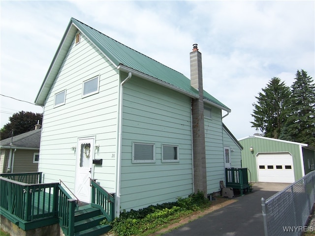 view of property exterior featuring a garage and an outbuilding