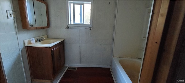 bathroom with vanity and tile walls