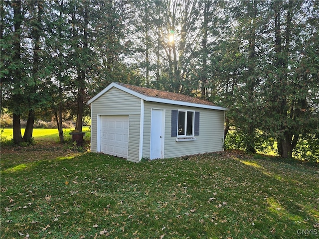 view of outdoor structure with a garage and a lawn