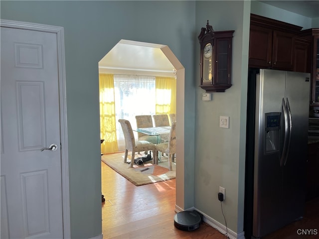 kitchen featuring stainless steel fridge with ice dispenser, light hardwood / wood-style flooring, and dark brown cabinets