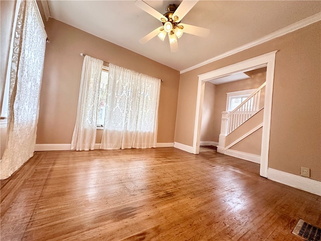 empty room featuring crown molding, hardwood / wood-style flooring, and ceiling fan