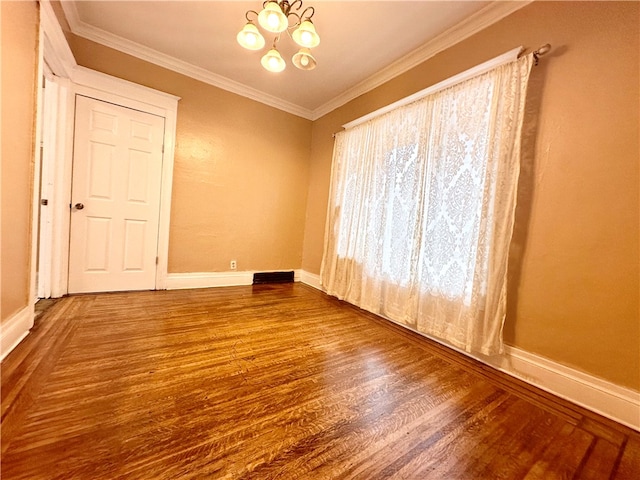 empty room with an inviting chandelier, ornamental molding, and wood-type flooring