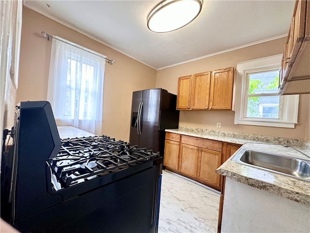 kitchen featuring stainless steel fridge, sink, black gas range oven, and plenty of natural light