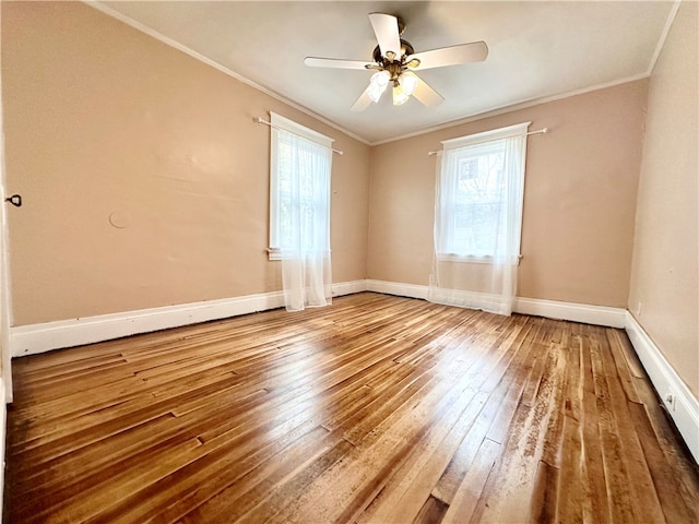 empty room with ceiling fan, ornamental molding, plenty of natural light, and hardwood / wood-style floors