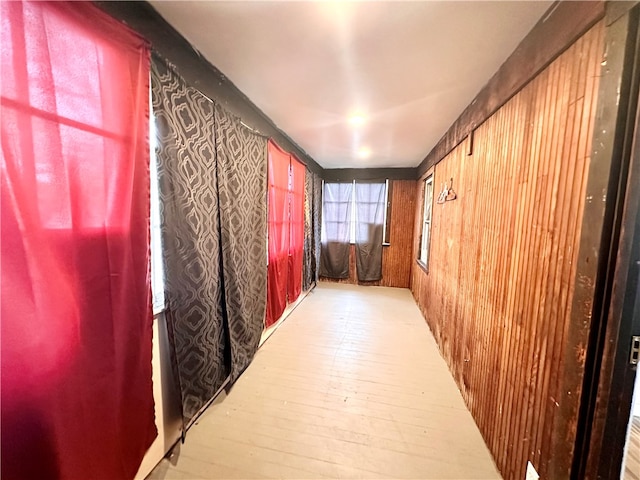 hallway featuring light hardwood / wood-style flooring and wooden walls