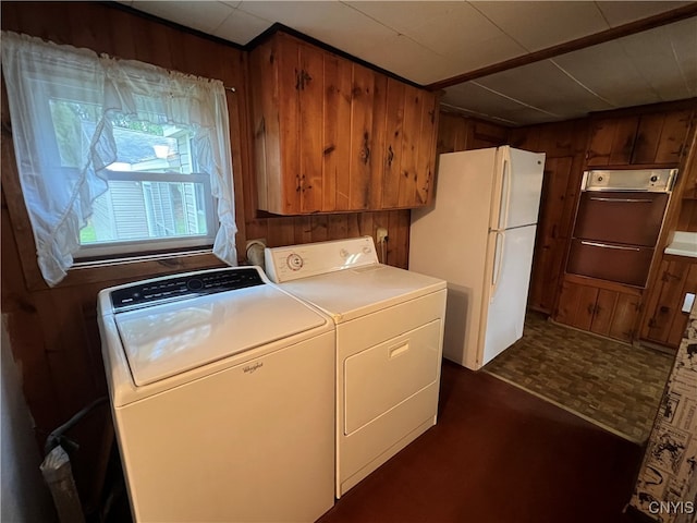 washroom with wooden walls, separate washer and dryer, and dark parquet flooring