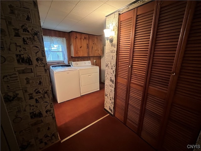 laundry room with wooden walls, separate washer and dryer, and dark carpet