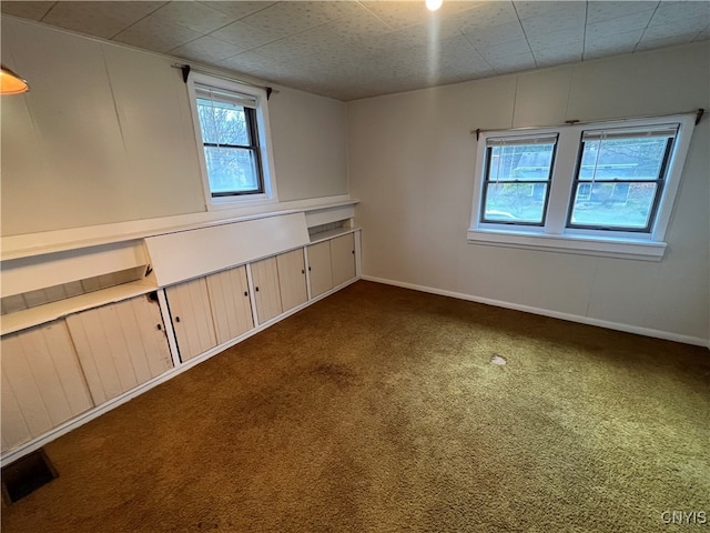 unfurnished room with dark carpet