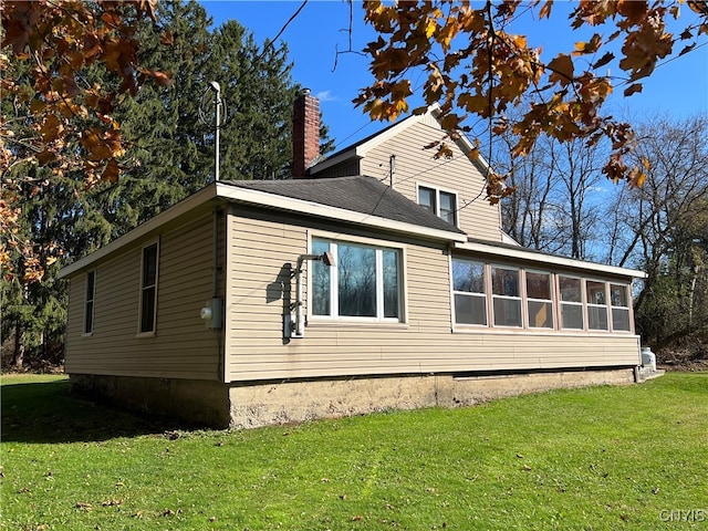 view of side of home with a yard and a sunroom