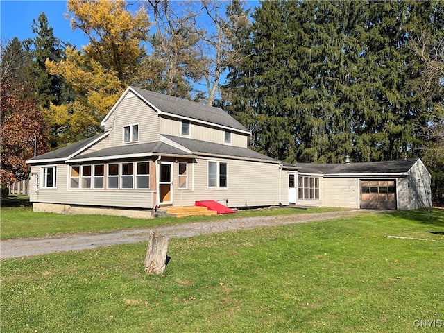 rear view of property featuring a yard and a sunroom