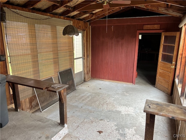 miscellaneous room featuring ceiling fan, vaulted ceiling, and wooden walls