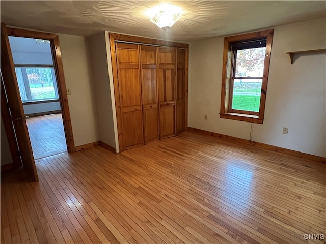 unfurnished bedroom featuring a closet and light hardwood / wood-style flooring