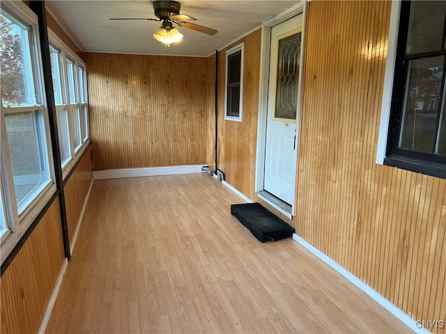 unfurnished sunroom with ceiling fan