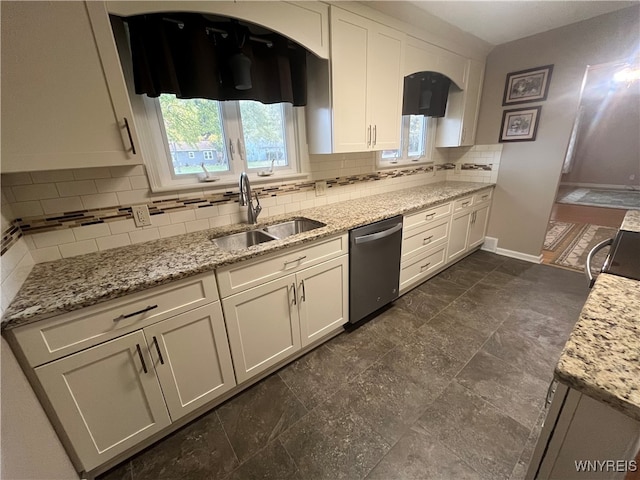 kitchen featuring tasteful backsplash, a wealth of natural light, sink, and stainless steel dishwasher