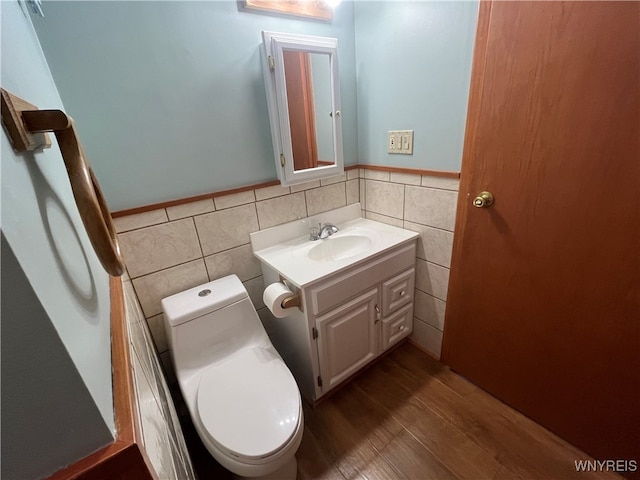 bathroom with tile walls, vanity, hardwood / wood-style flooring, and toilet