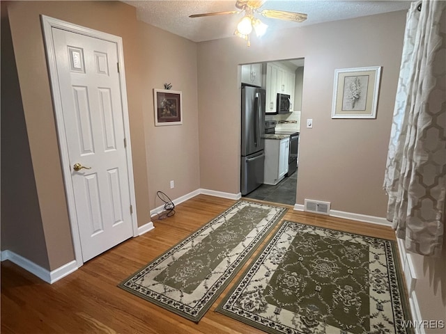 hall featuring hardwood / wood-style flooring and a textured ceiling