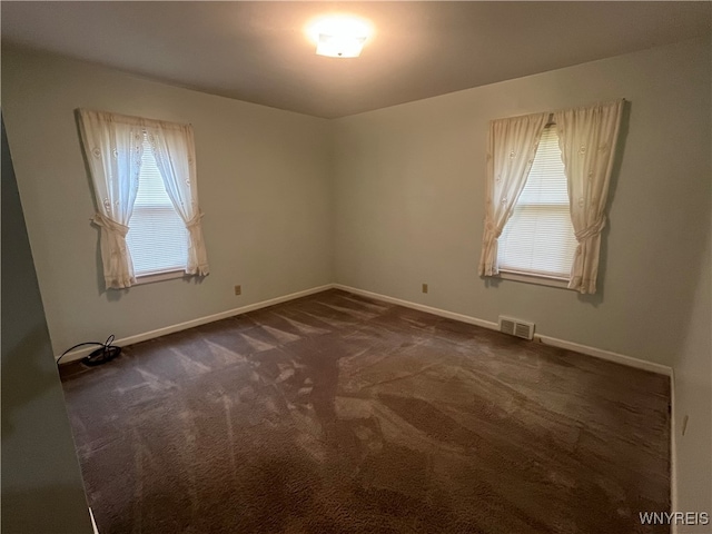 spare room with dark colored carpet